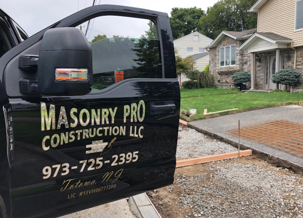 Compacted gravel base and wood forms set for a concrete sidewalk installation in Totowa, NJ