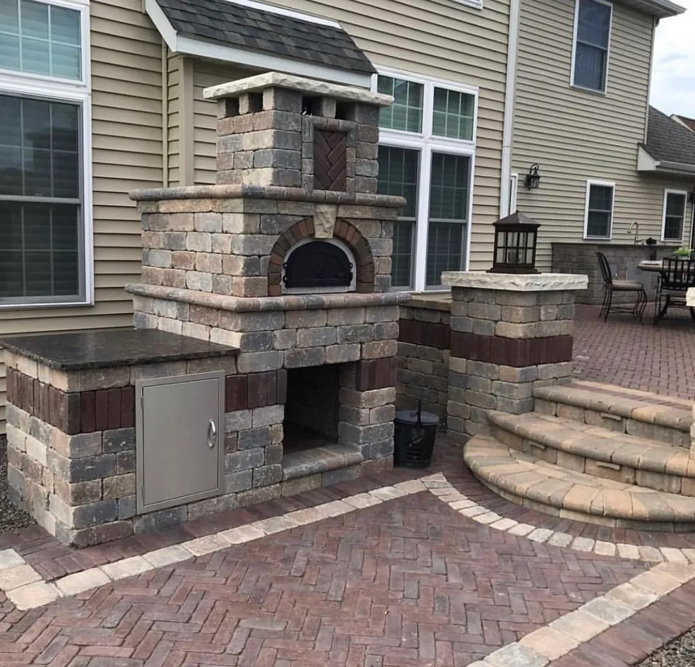 Custom outdoor kitchen with stone pizza oven, paver patio, and masonry steps completed at a residential property in North Haledon, Passaic County, New Jersey by Masonry Pro Construction.