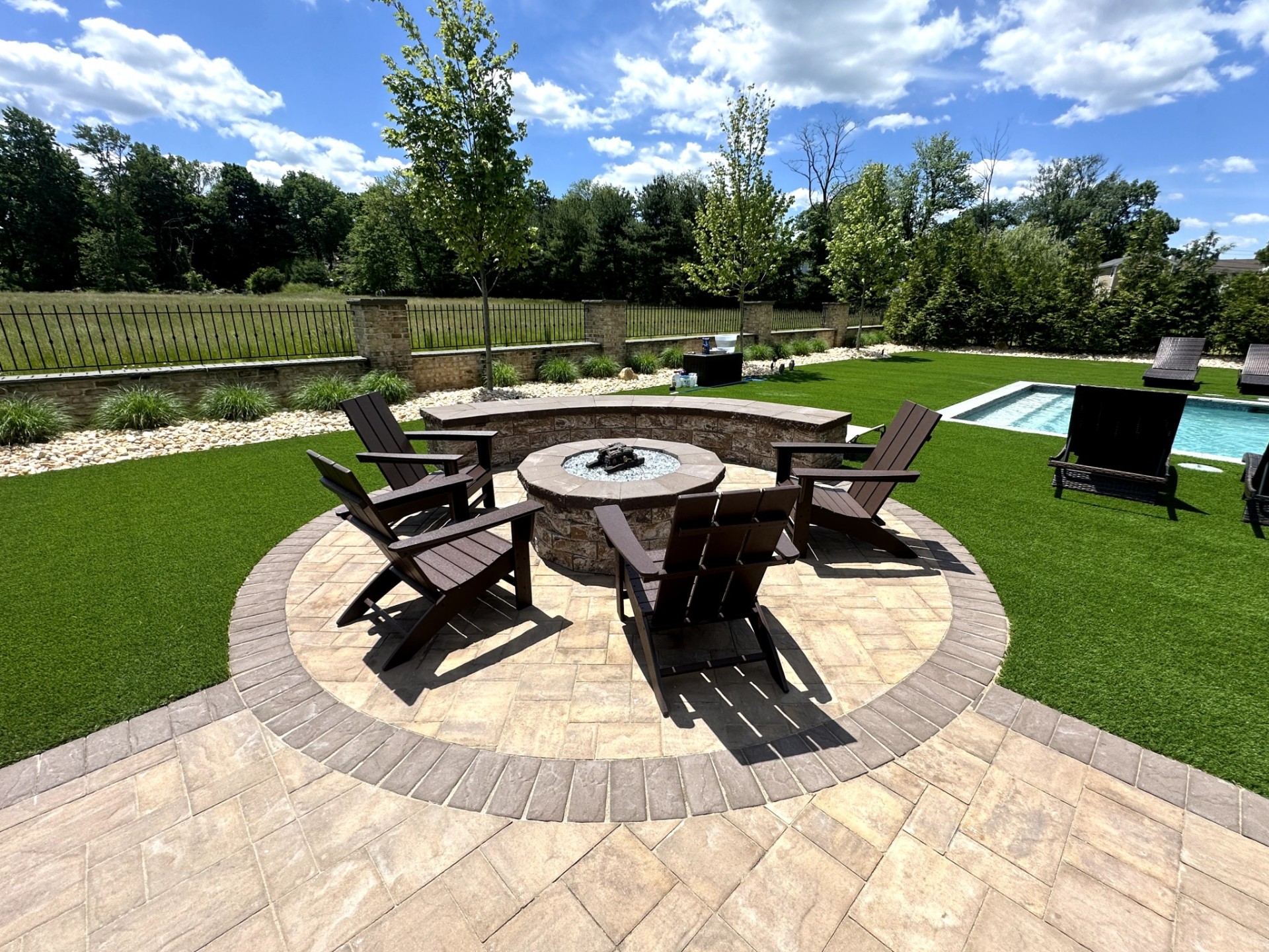 Custom stone fire pit completed in a backyard outdoor living space in North Caldwell, Essex County, New Jersey.