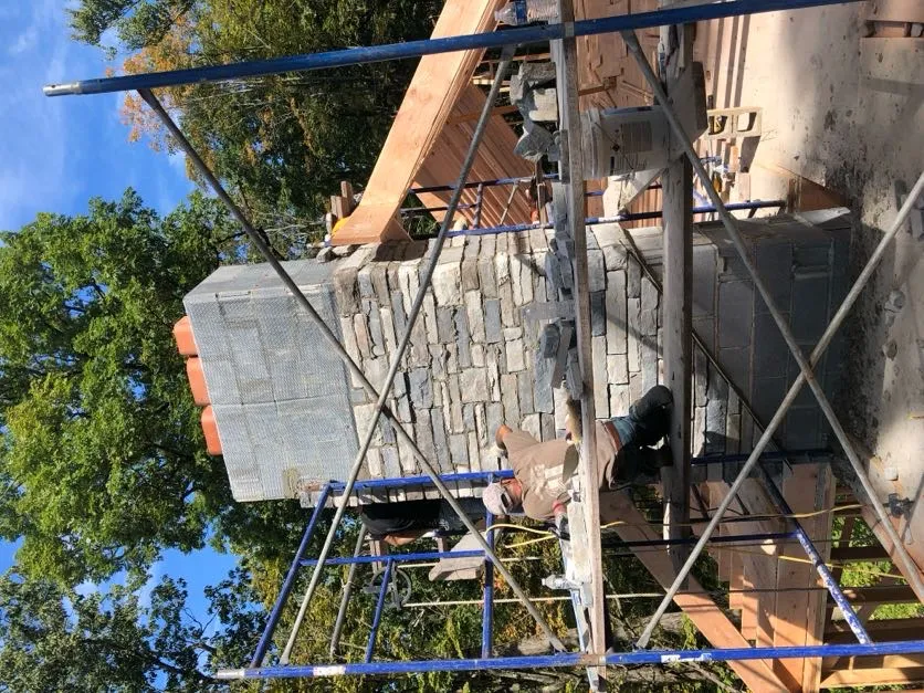 Mason installing a stone veneer on an outdoor fireplace in Wayne, Passaic County, New Jersey, 07470