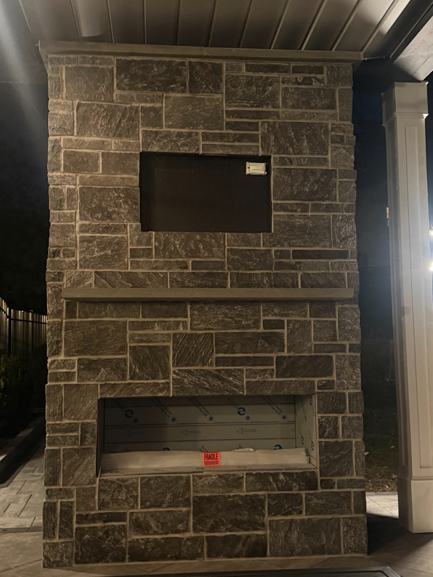 Outdoor fireplace installation with stone veneer in Short Hills, NJ