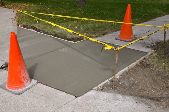 Freshly poured concrete sidewalk section with forms and rebar stakes in place in Totowa, NJ