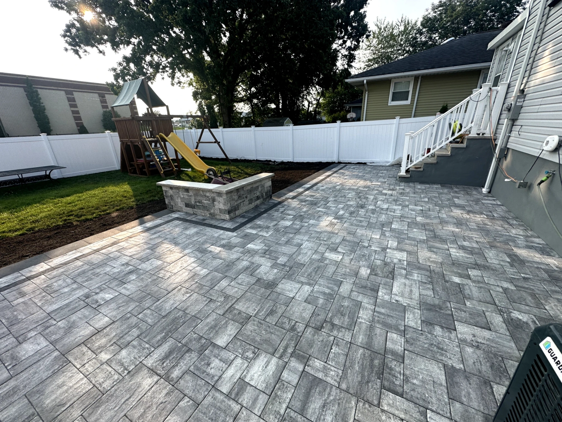 Backyard paver patio installation with stone seat wall and walkway at a home in Totowa, Passaic County, NJ, by Masonry Pro Construction.