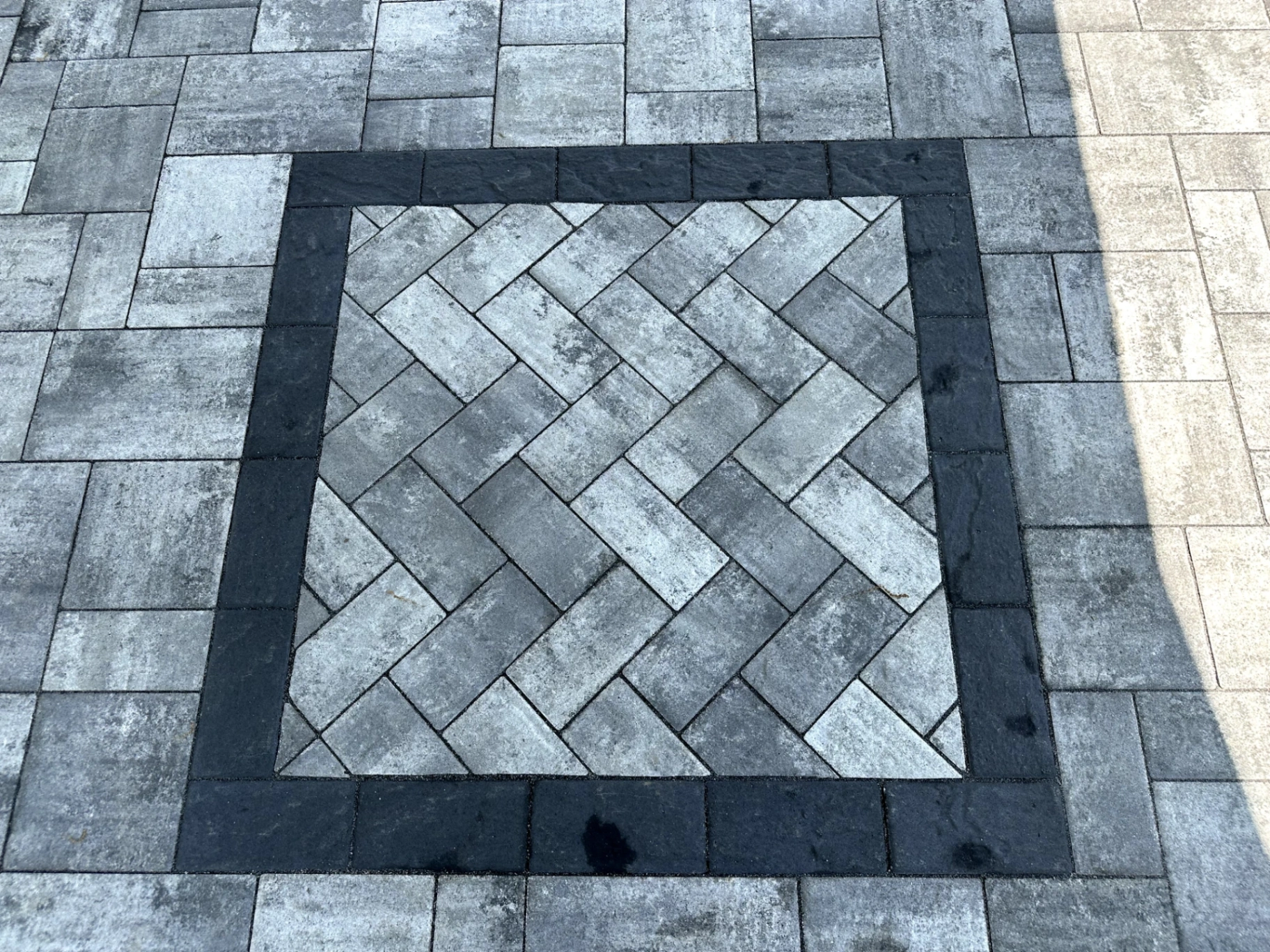 Close-up of herringbone paver patio pattern with dark border at a residential property in Montville Township, Morris County, NJ, by Masonry Pro Construction.