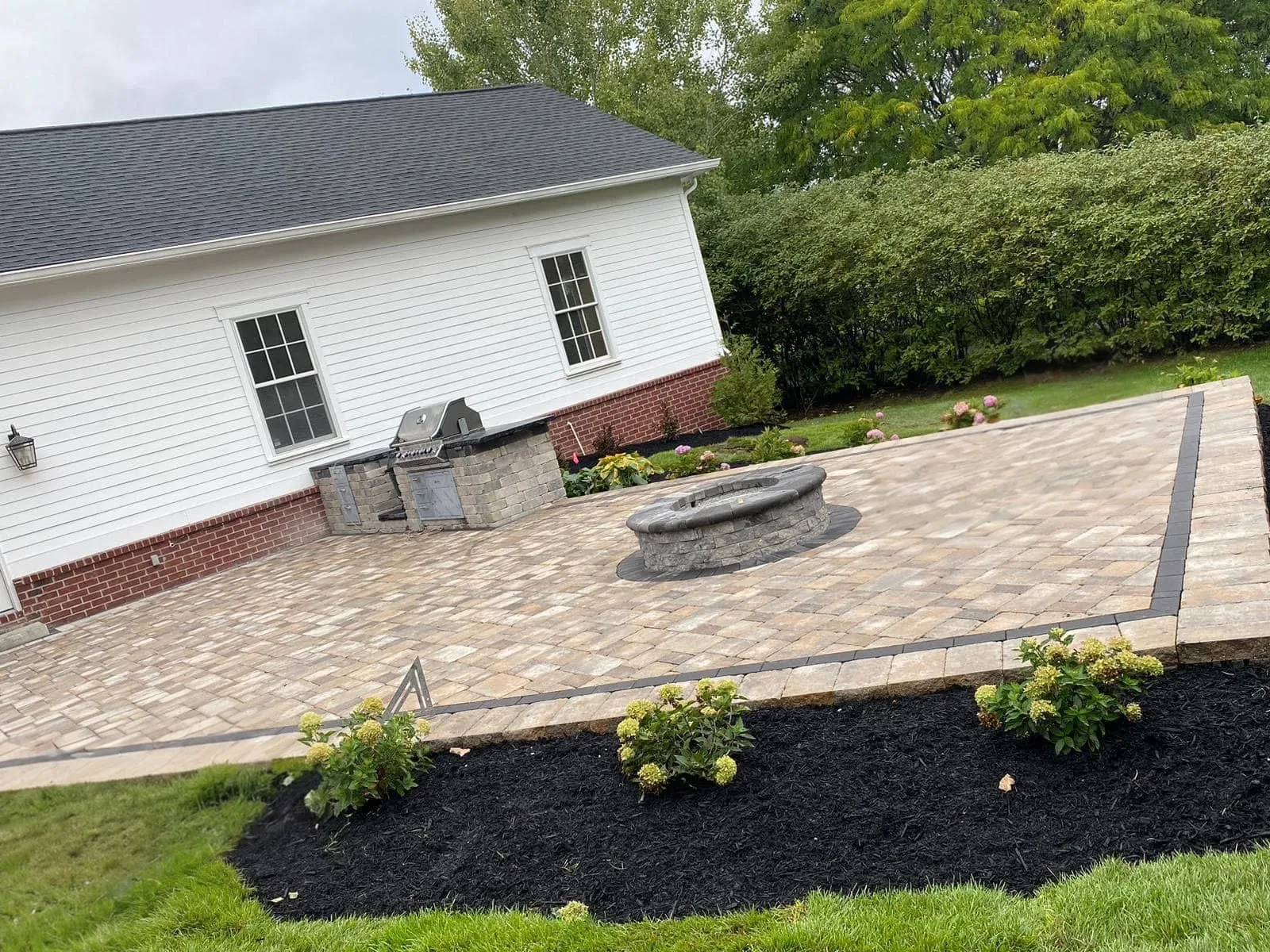 Paver patio installation with built-in fire pit and outdoor grill station at a residential home in Nutley, Essex County, NJ, by Masonry Pro Construction.