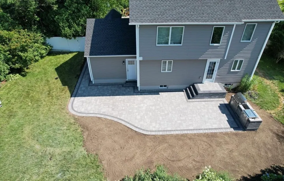 Aerial view of a completed paver patio installation with built-in grill area at a home in Oradell, Bergen County, NJ, by Masonry Pro Construction.