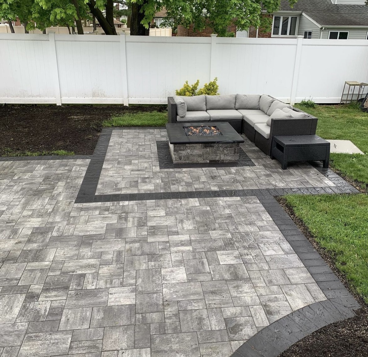 Modern gray paver patio with fire pit and outdoor sectional seating area installed in Montclair, Essex County, NJ, by Masonry Pro Construction.