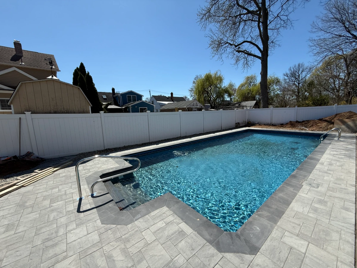 New swimming pool and paver patio installation in a residential backyard in Bloomfield, Essex County, NJ. Masonry Pro