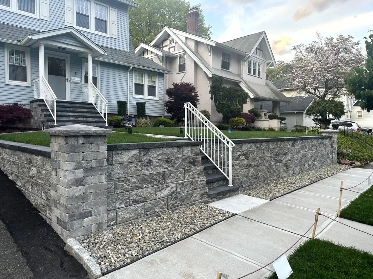 Completed stone retaining wall installation at a residential property in Nutley, Essex County, New Jersey by Masonry Pro Construction.