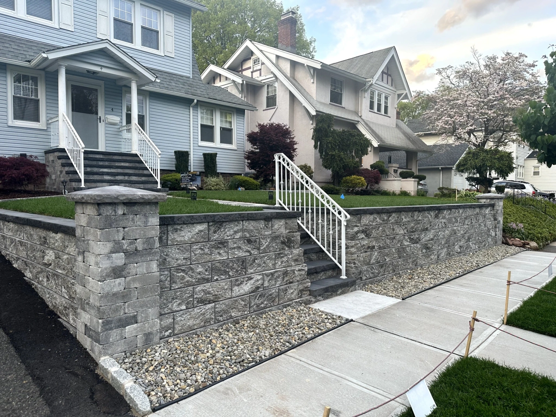 Completed stone retaining wall installation at a residential property in Nutley, Essex County, New Jersey by Masonry Pro Construction.