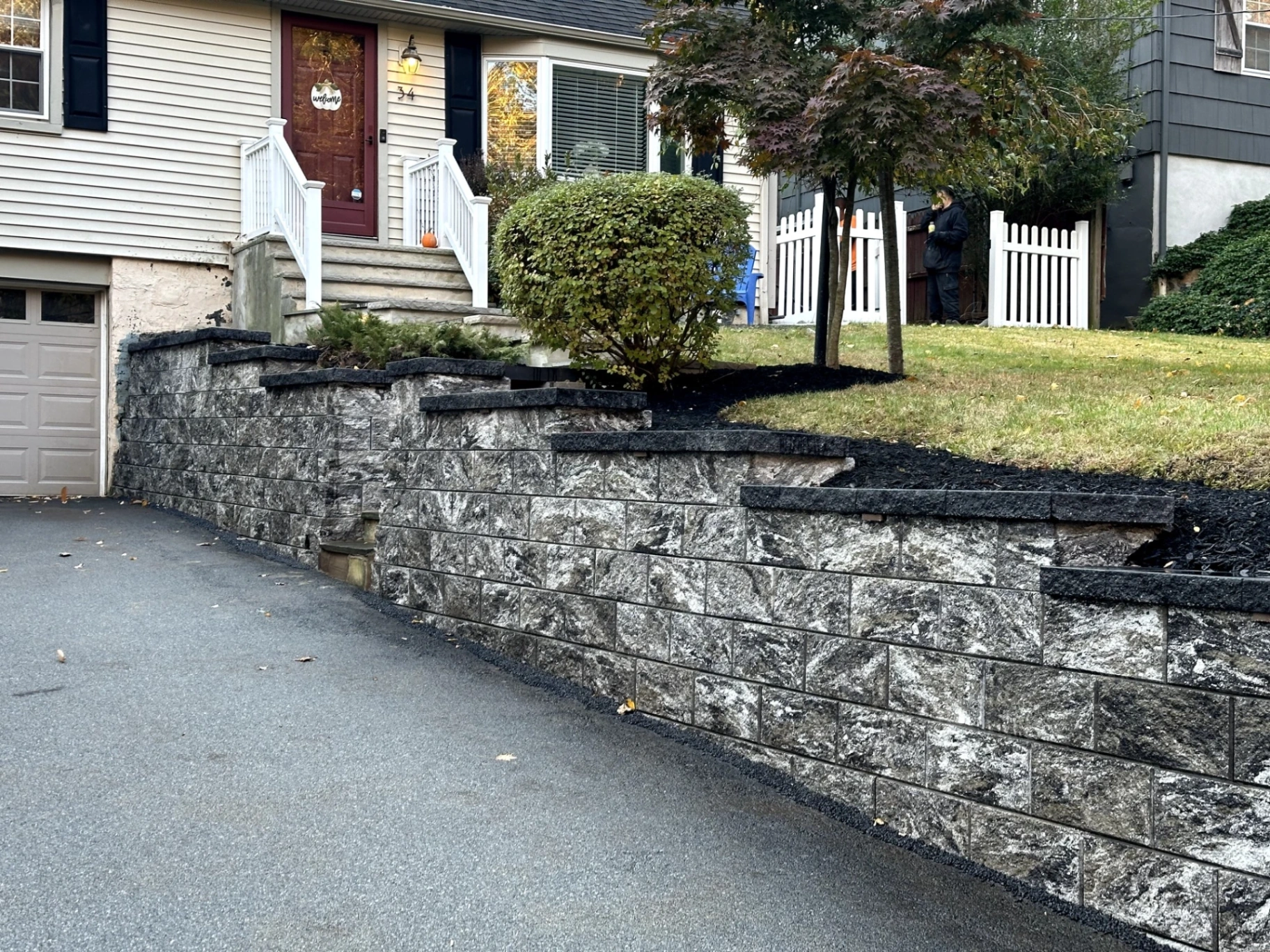 Completed block retaining wall providing yard leveling and erosion control in Morris Township, Morris County, New Jersey.