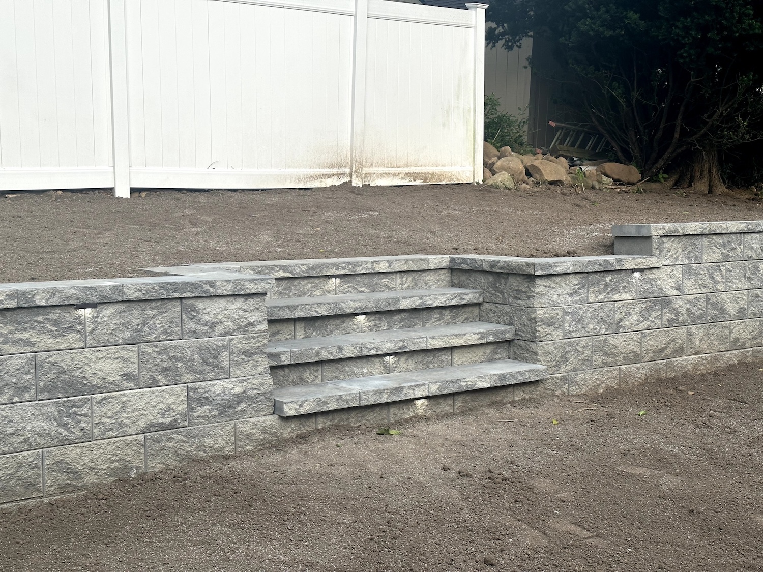 Completed retaining wall with integrated steps at a home in Wayne, Passaic County, NJ, by Masonry Pro Construction.