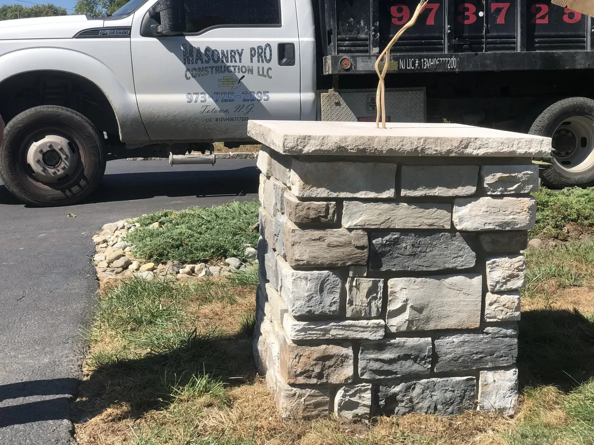 Masonry pro construction truck parked by a recently constructed natural stone pillar in Caldwell, Essex County, NJ.