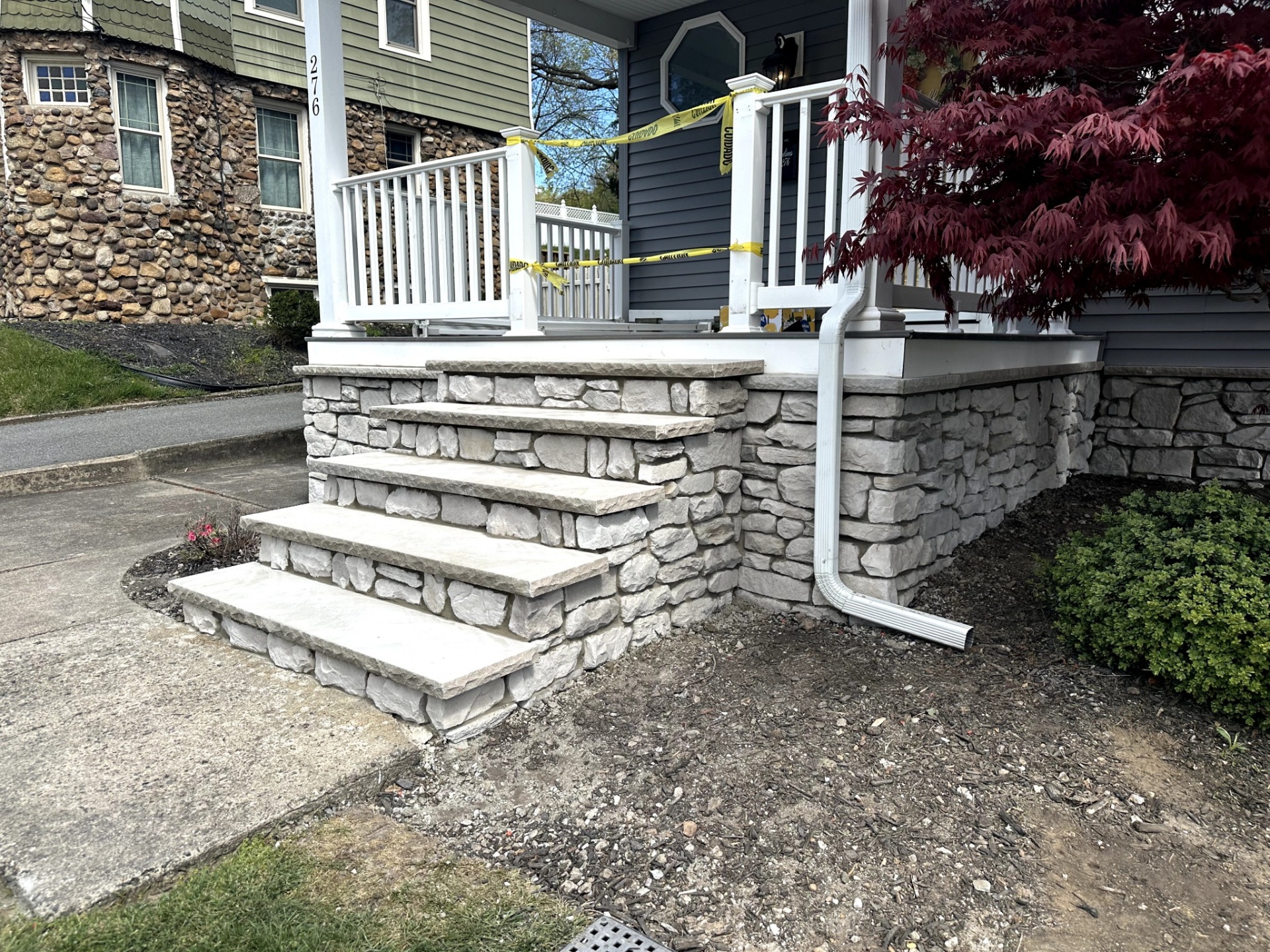 Newly installed custom stone masonry steps leading to a home's front porch in Verona, Essex County, NJ.
