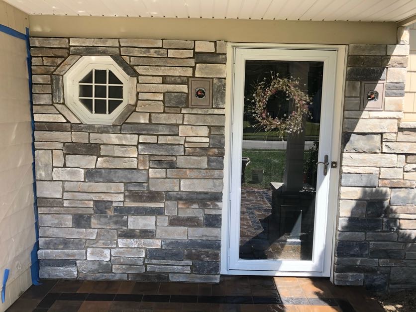 Natural stone veneer installation on a home front entrance with an octagonal window in West Caldwell, Essex County, NJ, by Masonry Pro Construction.