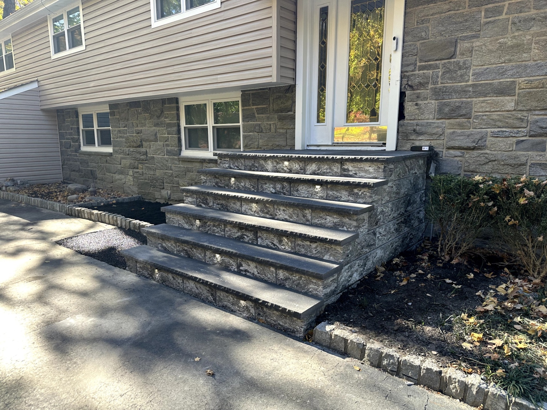 Newly installed stone veneer steps leading to a home with stone siding in Wayne, Passaic County, NJ, by Masonry Pro.