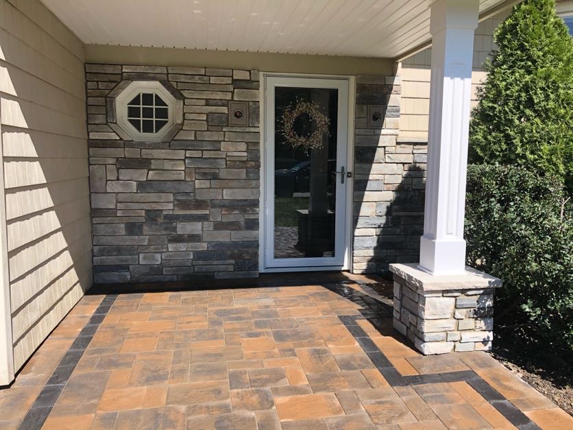 Stone veneer facade and paver porch installation at a residential home in West Caldwell, Essex County, NJ, by Masonry Pro Construction.