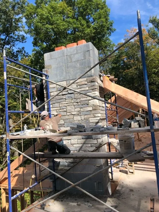 Masonry Pro building a stone work chimney on scaffolding in Pines Lake, Wayne, Passaic County, New Jersey, 07470.